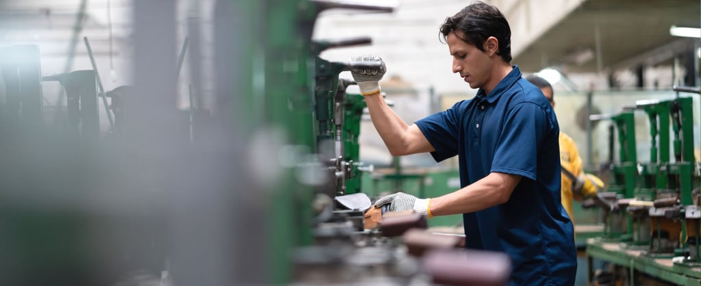 Trabajador operando maquinaria en una planta industrial, representando el Programa de Convergencia Social y Laboral SLCP en entornos de manufactura.