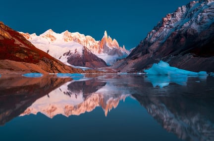 Mountains reflecting in a glacial lake at sunrise