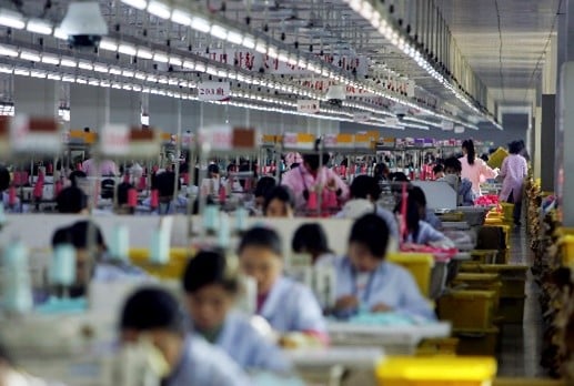Trabalhadores em linha de produção em fábrica têxtil