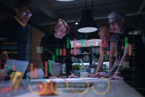 Equipe analisando informações e gráficos em ambiente de trabalho colaborativo